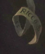 Signature — Ricco Wassmer · At the lower left, on the painted banner.
